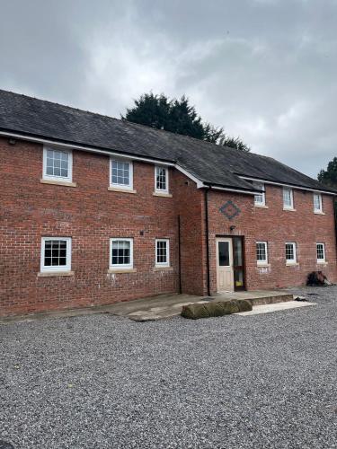 a red brick building with a lot of windows at Castell Cottages Central with Parking in Caerphilly