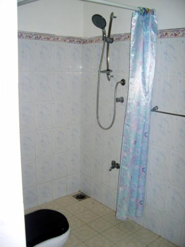 a bathroom with a shower with a toilet and a shower curtain at Sankarest Villa in Kosgoda