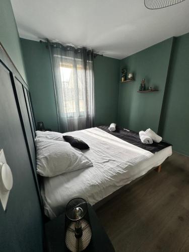 - une chambre avec un lit dans une pièce aux murs verts dans l'établissement L Elegant Cozy Plein Centre, à Saint-Avertin