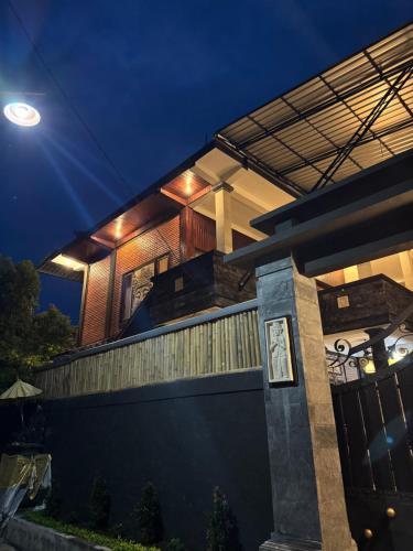 a house with a fence in front of it at night at Murni’s House in Lovina