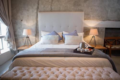 a large bed in a bedroom with two lamps at Leipzig Country House & Winery in Nuy