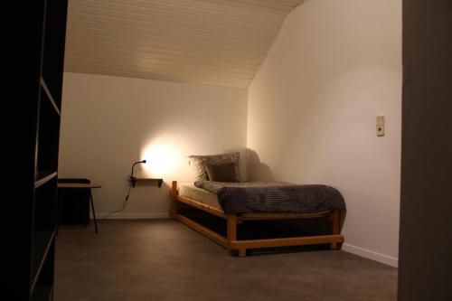 a bedroom with a bed and a light on the wall at Ferienwohnung Kloep in Serrig