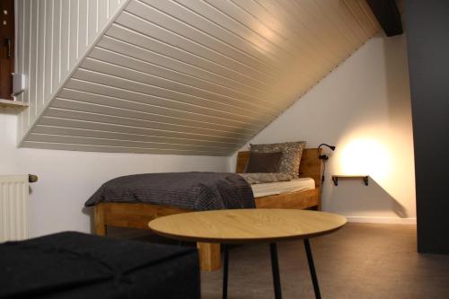 a attic room with a bed and a table at Ferienwohnung Kloep in Serrig