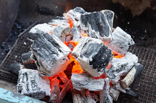 a pile of gray and orange rocks on a grill at GOMYO LIFE Hotel in Higashikagawa