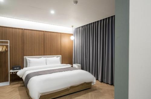 a bedroom with a large bed in a room at Hotel 7 Bricks Gwangju Sangmu in Gwangju