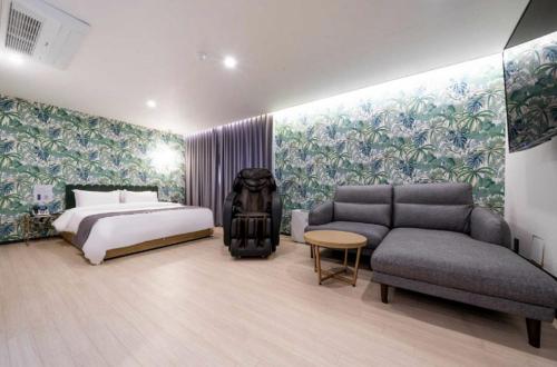 a hotel room with a bed and a couch at Hotel 7 Bricks Gwangju Sangmu in Gwangju