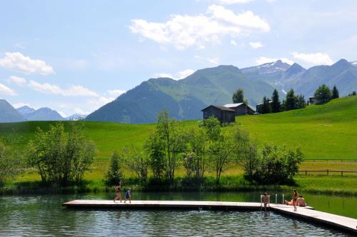 un grupo de personas en un muelle en un lago en Panoramic Ecodesign Apartment Obersaxen - Val Lumnezia I Vella - Vignogn I near Laax Flims I 5 Swiss stars rating en Vella