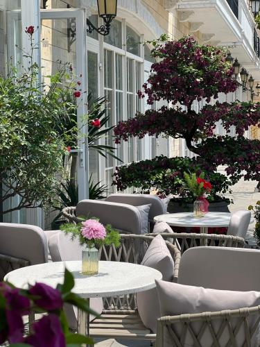 an outdoor patio with tables and chairs and flowers at HD Hotel Sunset Town in Phu Quoc