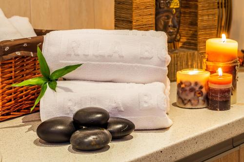 a pile of towels and candles on a counter at Rila Hotel Borovets in Borovets