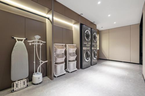 a room with three washing machines and a surfboard in it at HomeInn Plus at China Intl Exhibition Center and Liufang Subway Stn in Beijing