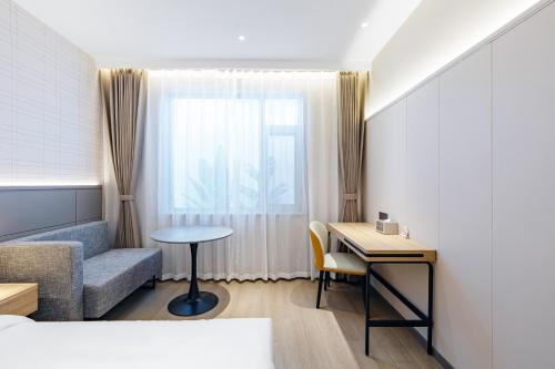 a hotel room with a bed and a desk and a window at HomeInn Plus at China Intl Exhibition Center and Liufang Subway Stn in Beijing