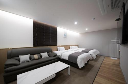 a bedroom with a bed and a couch at Hotel 7 Bricks Gwangju Sangmu in Gwangju
