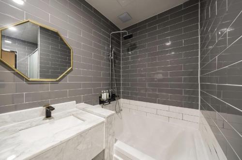 a bathroom with a tub and a sink and a mirror at Hotel 7 Bricks Gwangju Sangmu in Gwangju