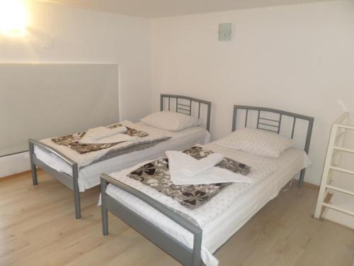 two twin beds in a room with a ladder at River Apartment in Mostar