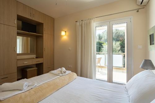 a bedroom with a bed and a sliding glass door at Avia Blue Maisonettes - Messinia Gulf Retreat in Avia