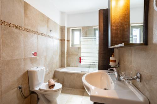 a bathroom with a toilet and a sink and a tub at Avia Blue Maisonettes - Messinia Gulf Retreat in Avia