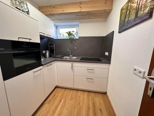 a kitchen with white cabinets and a black counter top at Ferienhaus Muskatellerhof in Silz