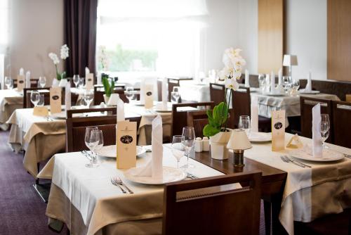 a dining room with tables and chairs with white tablecloths at Grand Hotel Primus - Terme Ptuj - Sava Hotels & Resorts in Ptuj
