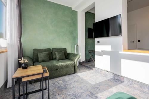 a living room with a couch and a tv at Hotel Südblick in Norderney