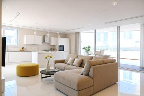 a living room with a couch and a table at Seaview Luxury Villa Jacuzzi & Pool! 2 Min Beach in Protaras
