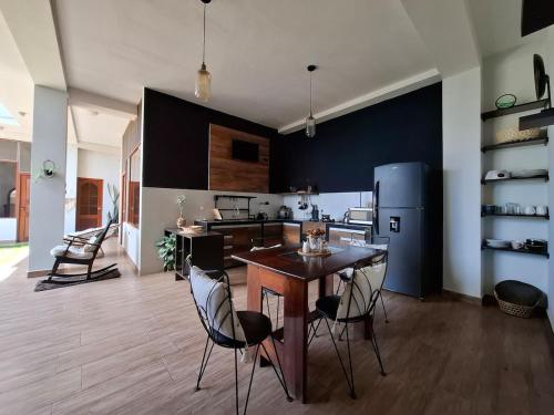 a kitchen with a table and chairs and a refrigerator at Garden House in Tarapoto