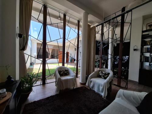 a living room with large glass windows and a couch at Garden House in Tarapoto