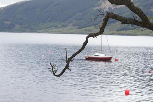 a small boat in the middle of a lake at Lochlomondlodge22 in Rowardennan