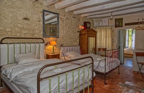 - une chambre avec 2 lits, une table et un miroir dans l'établissement Le trésor de grand-mére, à Montrésor