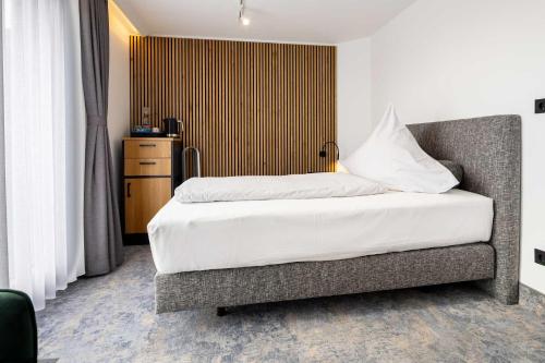 a bedroom with a bed and a dresser in a room at Hotel Südblick in Norderney