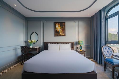 a bedroom with a large white bed and a chair at Lumina Dalat Premium in Xuan An