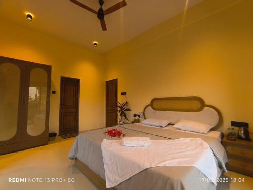 a bedroom with two beds and a ceiling fan at Lions Den luxury 4 BHK with private pool at tiger point near cloud nine in Āmbavna