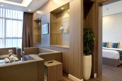 a hotel room with a couch and a bed at The Nalod Da Nang in Da Nang