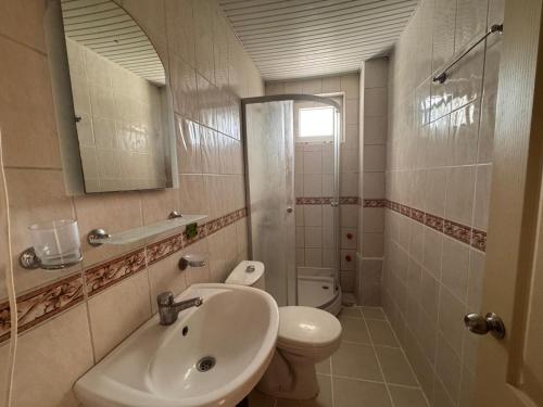 a bathroom with a sink and a toilet and a mirror at BEGONYA HOTEL KEMER-All İnclisuve in Antalya