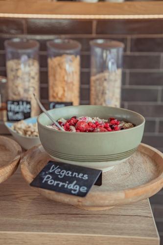 a bowl of food sitting on a table with a sign at Mariandl am Berg in Amberg