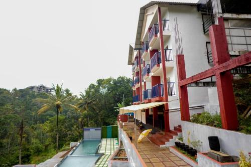 a building with a swimming pool next to a building at Velvet Vista Munnar in Munnar
