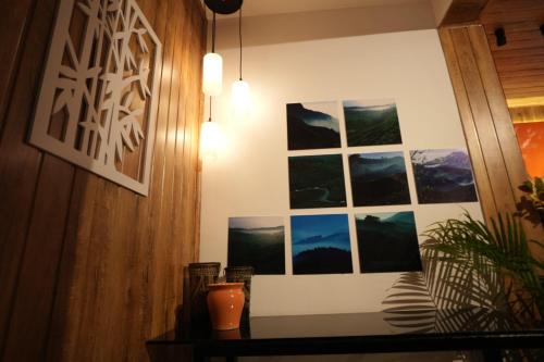 a room with pictures on the wall and a table at Velvet Vista Munnar in Munnar