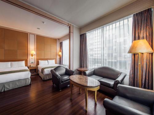 una camera d'albergo con letto e divano di Da Shih Hotel a Città di Hualien