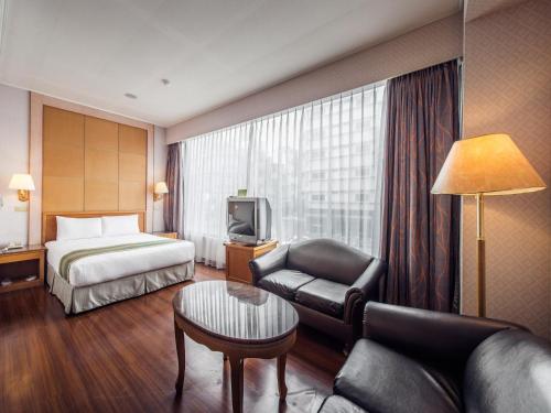 a hotel room with a bed and a couch at Da Shih Hotel in Hualien City