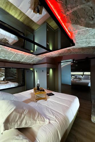 une chambre avec un grand lit blanc avec une poutre rouge dans l'établissement Love room La Toscana, à Romans-sur-Isère