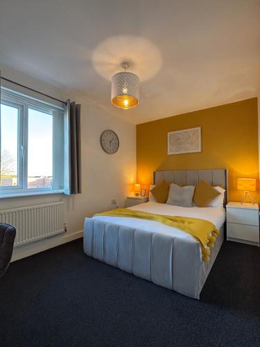 a bedroom with a large bed and a clock on the wall at Apollo Apartment in Coventry