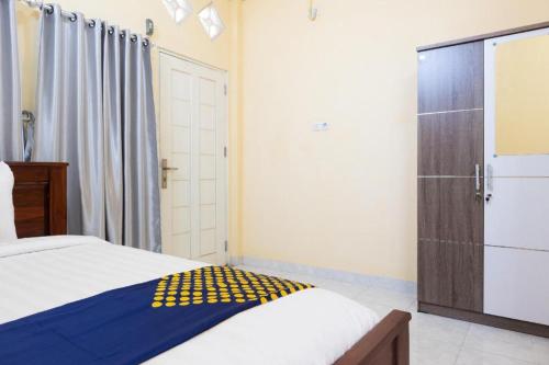 a bedroom with a bed and a closet and a shower at SPOT ON 2063 Bethania Residence in Kupang