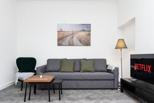 a living room with a couch and a table at 5 Individual Beds - Free Parking in Coatbridge