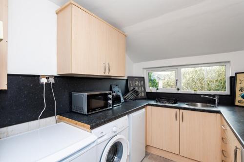 a kitchen with a sink and a microwave at 5 Individual Beds - Free Parking in Coatbridge