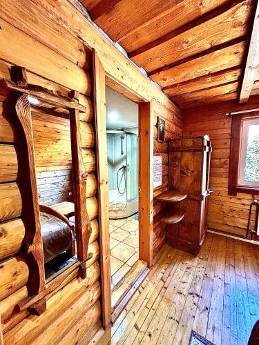 a log cabin room with a bed and a doorway at Ранчо в Карпатах in Bukovel