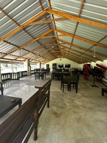 a large room with tables and chairs and a carriage at New Sigiri Kele in Sigiriya