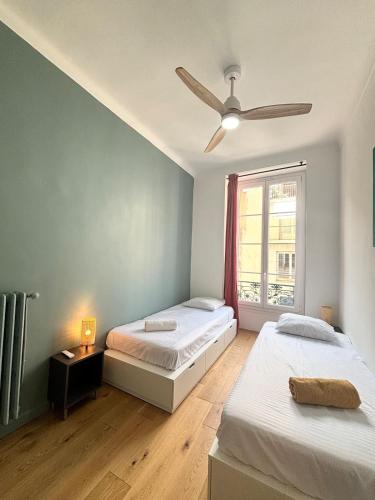 une chambre avec deux lits et une fenêtre dans l'établissement Apartment near the Gare du Sud, à Nice