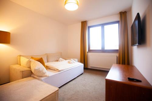 a living room with a bed and a window at Penzión na Bezovci in Nová Lehota