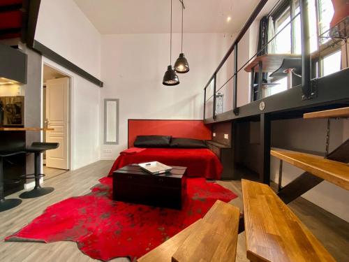 - une chambre avec un lit rouge et un tapis rouge dans l'établissement LE LOFT des Charmettes, à Lyon