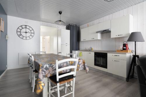 une cuisine avec une table et des chaises dans une cuisine dans l'établissement Le Reflet des Pyrénées, à Bagnères-de-Bigorre