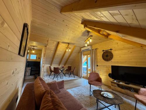 a living room with a couch and a tv at Brvnara La Forêt in Žabljak